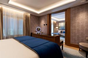 马德里Wellington Hotel & Spa Madrid的一间卧室配有一张床、一张桌子和一把椅子
