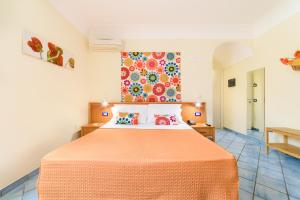 阿马尔菲沙伦豪斯别墅酒店的一间卧室配有一张带橙色床罩的床