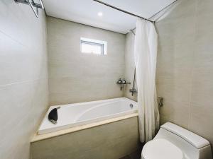河内Hanoi Home 8 - Luxury Apartment, open view的带浴缸和卫生间的浴室。