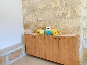 伯利恒Dar Ateeq's Arches/ Bethlehem Apartment的木柜,上面有毛巾和动物填充物