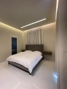 塞拉莱Rateel Apartments的一间卧室配有一张带白色床单的大床