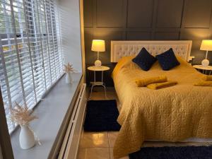 斯旺西Spacious 1 bed bungalow located on a Gower Sheep Farm的一间卧室配有一张带黄色毯子和枕头的床。