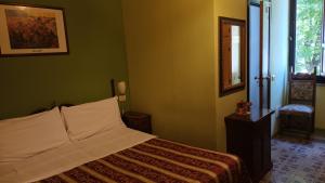 佩鲁贾欧罗巴酒店的一间设有床铺的卧室,位于一个拥有绿色墙壁的房间