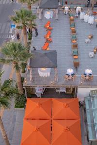 罗希姆诺拉奎拉波尔图雷斯蒙酒店的享有带桌子和橙色遮阳伞的天井的顶部景致。
