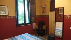 佩鲁贾欧罗巴酒店的一间卧室配有一张床、一张书桌和一个窗户。