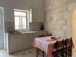 伯利恒Dar Ateeq's Arches/ Bethlehem Apartment的厨房里配有一张桌子,上面有一盘水果