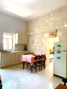 伯利恒Dar Ateeq's Arches/ Bethlehem Apartment的厨房配有桌子和冰箱