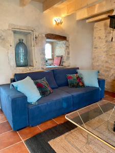 圣昂托南La Pause noble val的客厅配有带枕头的蓝色沙发