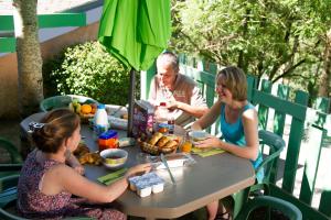 Brassacvillage vacances du camboussel的坐在餐桌旁吃着食物的男人和女人