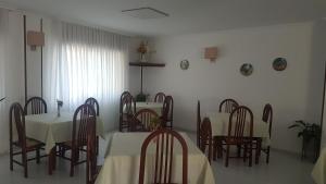 波多诺伏旁塔斯姆酒店的用餐室配有白色的桌子和木椅