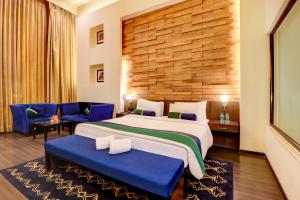 斋浦尔Sunday Hotel Jaipur的酒店客房带大床和蓝色椅子