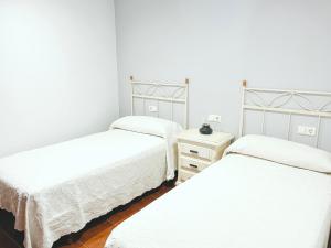 科巴罗CASA CASTAÑEIRA的带三张床的房间和带两张床的床头柜