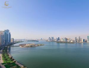 沙迦Corniche Hotel Sharjah的城市河流上的一艘大船