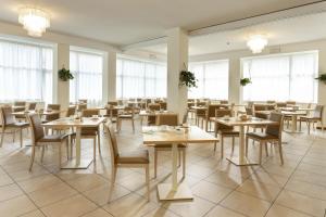 里米尼比基尼酒店的用餐室设有桌椅和窗户。