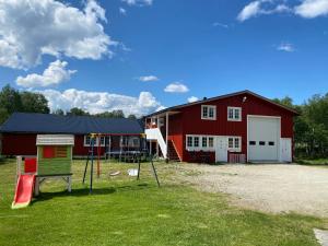 勒罗斯Leilighet Sølendet, i Brekken ved Røros的前面有一个红色谷仓,上面有一个操场