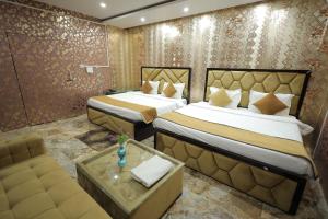 范兰德凡Tulsi Garden- Near Prem Mandir Vrindavan的酒店客房,设有两张床和一张沙发