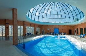 奥亨Hotel Wellness Marbella Hills的一座大型游泳池,在大楼内设有一个玻璃圆顶