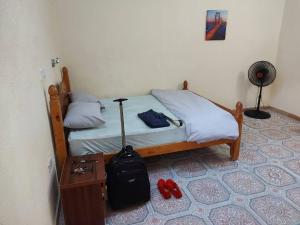 贝宁城Charming 2-Bed Cottage in Benin City的一间卧室,配有一张床,包括手提箱和红色鞋