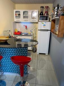 纳塔尔Nosso lar em Natal - quarto的一间带桌子和冰箱的小厨房