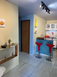 纳塔尔Nosso lar em Natal - quarto的柜台前带红色凳子的厨房