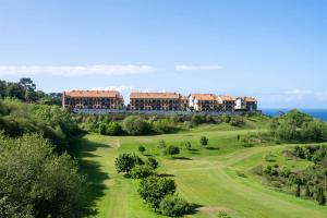 柯米拉斯Abba Comillas Hotel的从高尔夫球场欣赏到度假村的景色