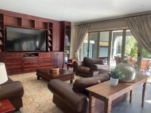 帕雷斯Riverfront Golf Estate House的客厅配有皮革家具和平面电视