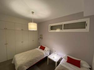 波里斯-德阿沃纳Apartamento cerca del mar的一间卧室设有两张床、一张桌子和一个窗口