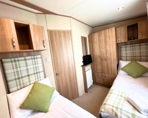 罗切斯特Haven Holiday Home at Kent Coast Allhallows的小房间设有两张床和电视