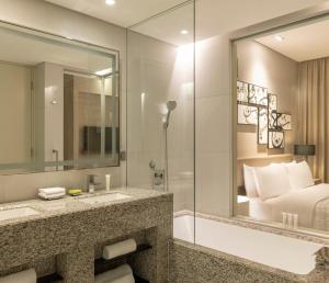 麦纳麦巴林墨丽婷市中心酒店的一间带水槽和浴缸的浴室以及一张床