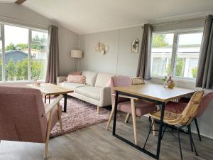 荷属圣马丁Chalet 572 op Recreatiepark De Wielen的客厅配有沙发和桌子