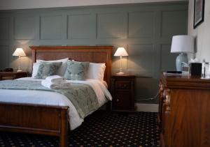 考布里奇The Bear, Cowbridge的一间卧室配有一张带两盏灯和两张桌子的床。