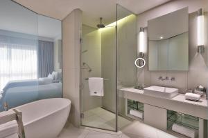 麦纳麦巴林威斯汀市中心酒店的一间带玻璃淋浴、浴缸和水槽的浴室