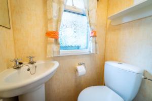 米科瓦伊基Camping KamA的一间带卫生间、水槽和窗户的浴室