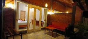佩母德兰库布库环保潜水瑜伽旅馆的一间设有红色长椅的房间和一间卧室
