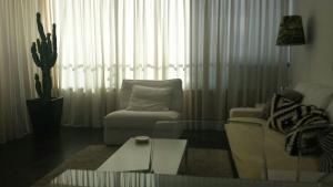 英格兰海滩Apartamento Paco的客厅配有沙发、椅子和桌子