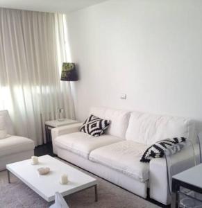 英格兰海滩Apartamento Paco的客厅配有白色的沙发和桌子