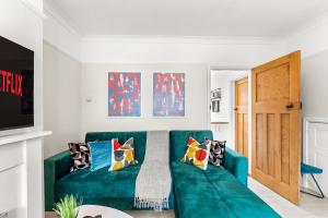 EarlhamStunning Norwich Gem Sleeps 7 - Parking - Garden的客厅配有带枕头的绿色沙发