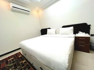 苏尔Al Taraf Hotel Apartment的卧室配有一张白色大床和空调。