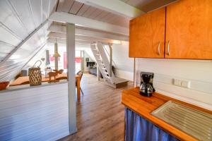 孙登Nordic Ferienpark Sorpesee的一个小房子里的厨房和客厅,有楼梯