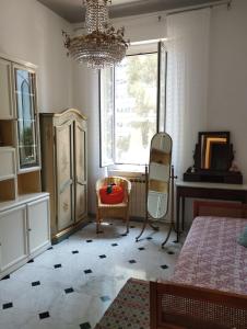 热那亚Casa Nonna Anna的一间卧室配有吊灯、椅子和窗户
