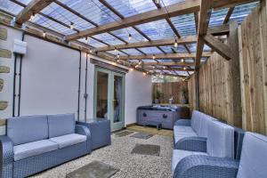 BamptonOlive Cottage by Group Retreats的一个带蓝色椅子和玻璃屋顶的庭院