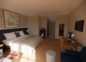 基茨比厄尔HENRI Country House Kitzbühel的一间卧室配有一张床、一张桌子和一张沙发