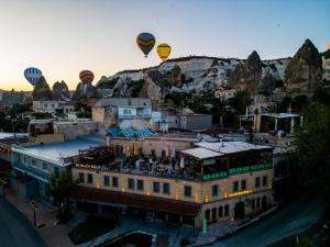 格雷梅Nomads Cave Hotel & Rooftop的一组热气球飞越一座建筑物
