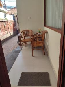 沙努尔Kubu Di-Kayla's的阳台配有2把椅子和桌子