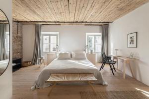 卢布尔雅那April1550 Boutique Hotel的一间卧室设有一张带木制天花板的大床