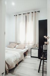 巴塞罗那鲁塔弗朗西亚旅馆的卧室设有两张床,配有白色窗帘