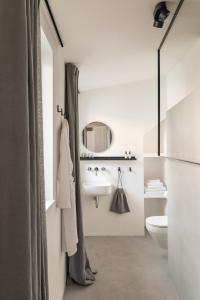 卢布尔雅那April1550 Boutique Hotel的白色的浴室设有水槽和镜子