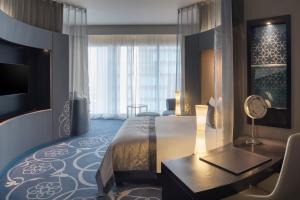 多哈W Doha的酒店客房配有一张床、一张书桌和一台电视。