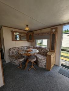 达农30 Glenfinart Caravan Park的客厅配有沙发和桌子