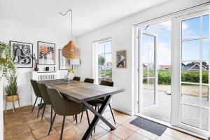 布罗Charming Architect-designed Terraced House With Sea View的一间带木桌和椅子的用餐室